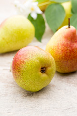 Fresh pears with leaves in a on wooden background.