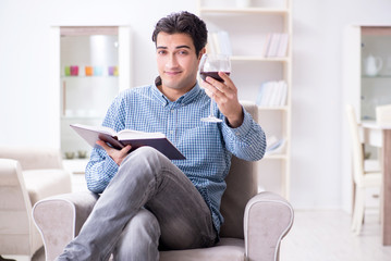 Fototapeta premium Young man drinking wine at home