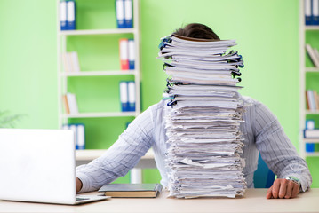 Businessman having problems with paperwork and workload