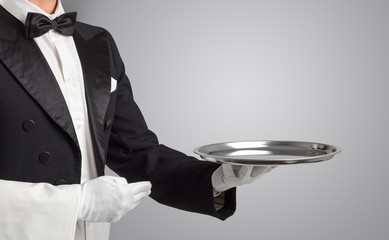 Waiter serving with white gloves and steel tray in an empty space

