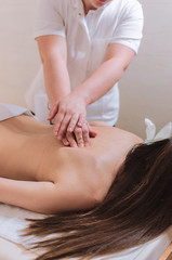 Fototapeta na wymiar Young woman receiving back massage in beauty spa salon.