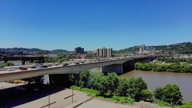A slow push forward aerial establishing shot of Pittsburgh's Veterans Bridge over the Allegheny River on a sunny summer day.  	