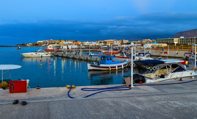 An evening view of seashore with pier and ships, island of Crete in Greece