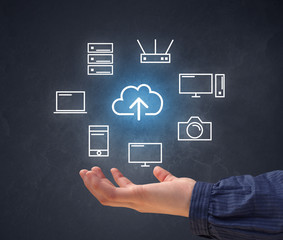 Cloud and computing related icons hovering over young hand 
