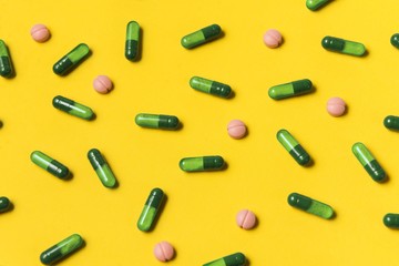 Capsule pills on yellow background. Medical pills. Pharmacy medicaments.