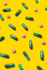 Capsule pills on yellow background. Medical pills. Pharmacy medicaments.