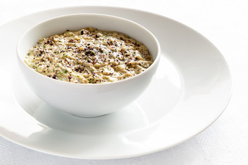 roasted eggplant dip with tahina, green herbs, garlic, and lemon juice decorated with sumac