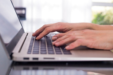 Woman with the hands over the laptop keyboard.