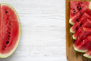 Fresh cut watermelon with slices on a white wooden background. Copy space.