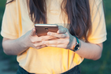 Smartphone closeup in womans hands. Teenage girl holding a phone. Woman touching a screen