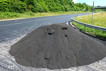 Großer Haufen loser Asphalt an einer frisch sanierten Straße