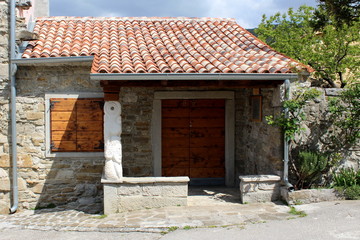 Fototapeta na wymiar Traditional Mediterranean stone house with new roof tiles, wooden windows blinds and drain pipe