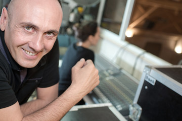 engineer sitting at mixing desk in recording studio