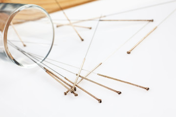 Silver needles for traditional Chinese acupuncture medicine. White background.