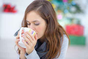happy young woman drinking tea while relaxing at home