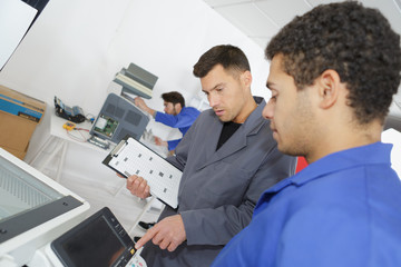 manufacture workers working on electronic machine