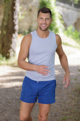 Fototapeta premium handsome young man doing sports and jogging in a park