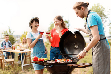 Young people having barbecue with modern grill outdoors