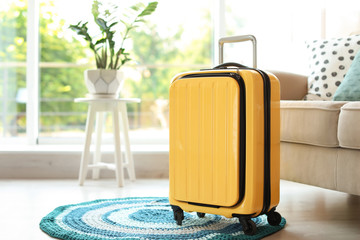 Bright yellow suitcase packed for journey at home