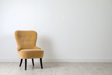 Stylish comfortable armchair near light wall indoors