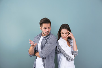 Upset young couple on color background. Relationship problems