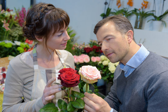 Florist looking at roses with customer