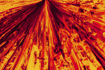 Abstract micrograph of bright red and orange pattern of lysine crystals.