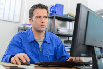 Manual worker sat at his desk