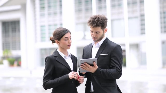 Couple of business people using a tablet outdoor