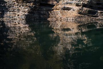 An odd rock formation reflected in a body of water