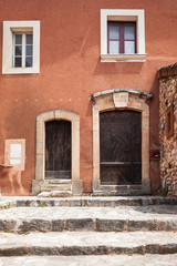 Old buiding with wooden door in Roussillon, Provence, France