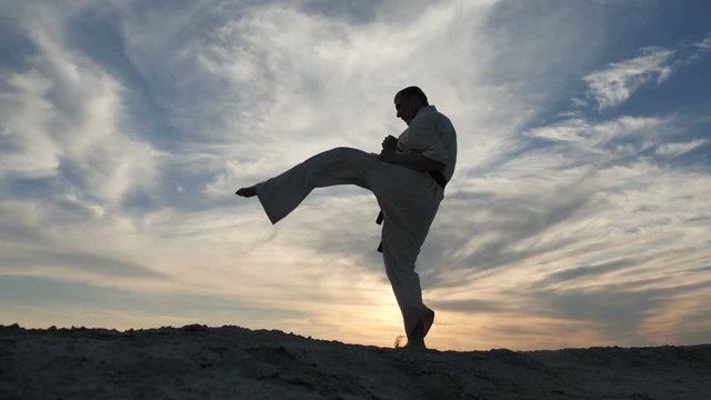 Silhouette of an athlete actively preparing for karate battle