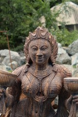 Fototapeta na wymiar Beautiful/perfect sculpture of Dancing devadasi Holding musical instrument on her hand carved from red sand stone with natural background.An female servant of god or jogini is a girl.Odisha,July/7/18
