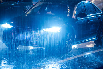 Cars driving on wet road in the rain with headlights