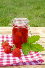 strawberry jam in  glass jar on a wooden background. Berry season. strawberry crop	