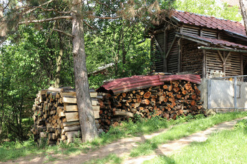 Pile of firewood near the fence of a private house