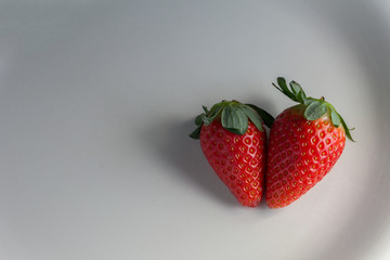 Fresh strawberries in the white plate made of porcelain white background