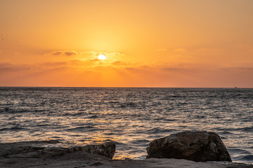 Fototapeta premium sea, sunset, stones, elements, waves, solitude, freedom, sun, orange, blue, drops, splashes