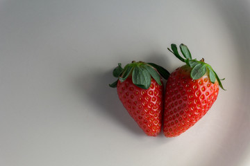Fresh strawberries in the white plate made of porcelain white background