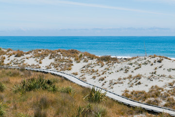 Fototapeta premium Wooden walking path over ocean skyline background