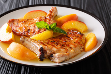 grilled spicy pork fillet with peaches, honey garlic sauce and mint closeup on a plate. horizontal
