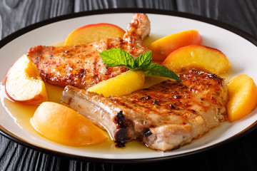 Organic food: grilled spicy pork with glazed fresh peaches and mint closeup. horizontal