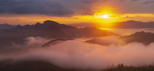 spectacular, fairytale sunset over the mountains, floating mist highlighted by the setting sun,...