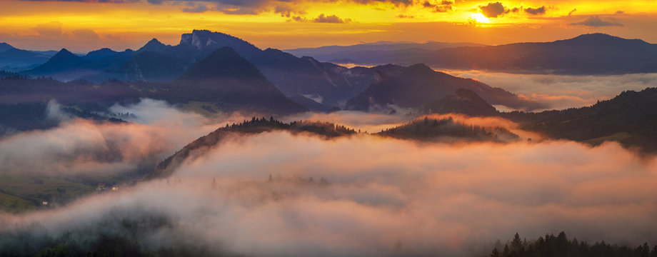 Fototapeta spectacular, fairytale sunset over the mountains, floating mist highlighted by the setting sun, Pieniny, Slovakia