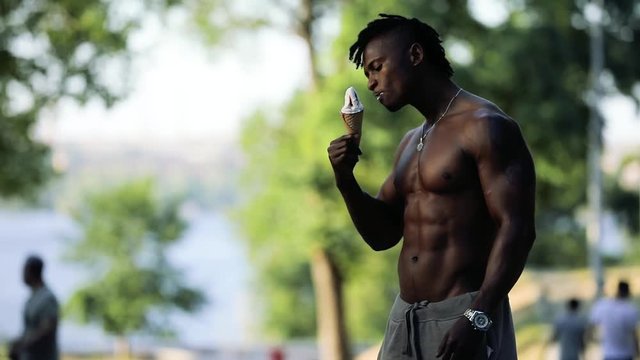 African macho man topless eating ice cream