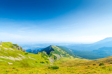 picturesque mountainside with green lawn, the Tatra Mountains and the top of Kasprowy Wierch, Poland