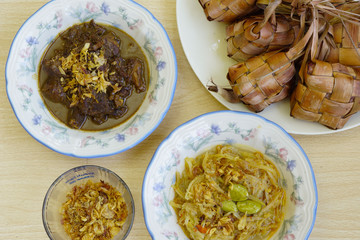 Rice cakes together with beef stew, chayote soup, unpeeled rice cakes and dried onion ares served  captured top view. 