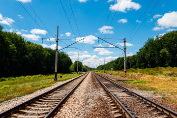 Scenic railroad in rural area and blue sky with white clouds in summer