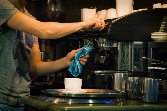 waiter cleaning coffee machine