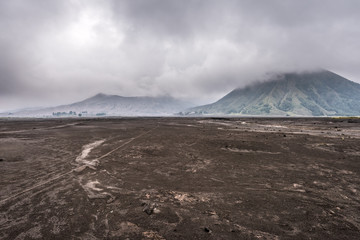 Mount Bromo under cloud with the sand sea as foreground